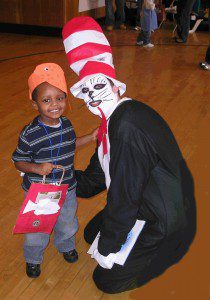 smiling child with adult in Dr. Seuss costume at Halloween